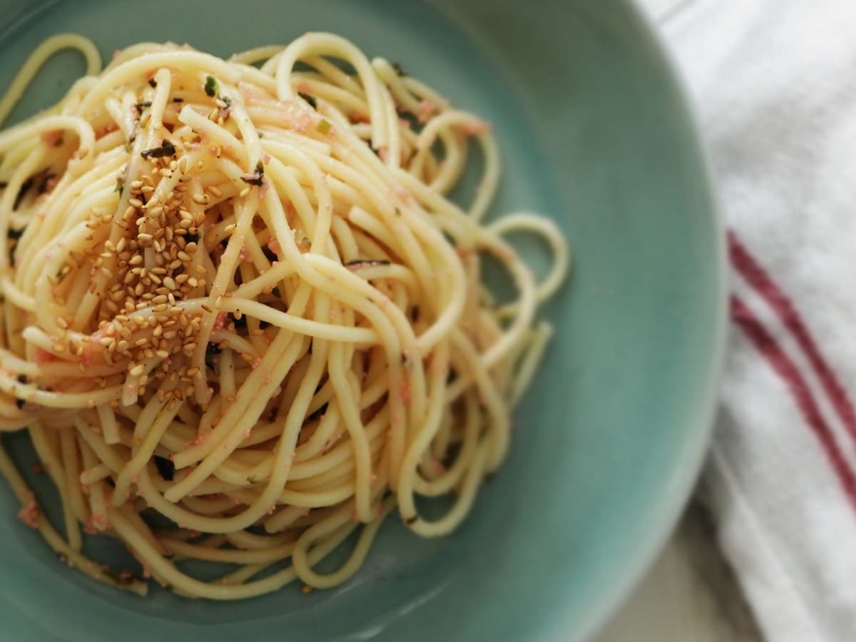 Ein blauer Teller mit Miso Butter Pasta auf einem Geschirrtuch.