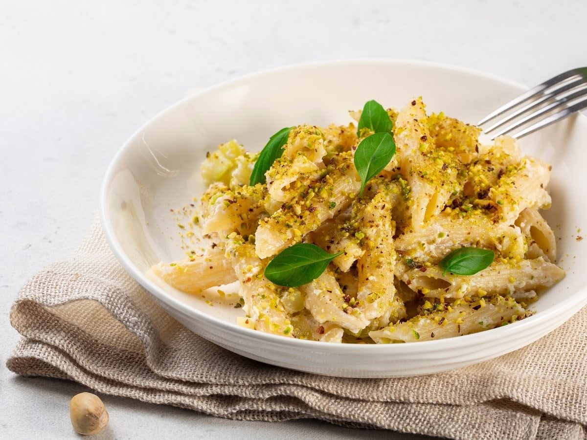 Ein weißer Pastateller mit Pasta mit Pistaziencreme.