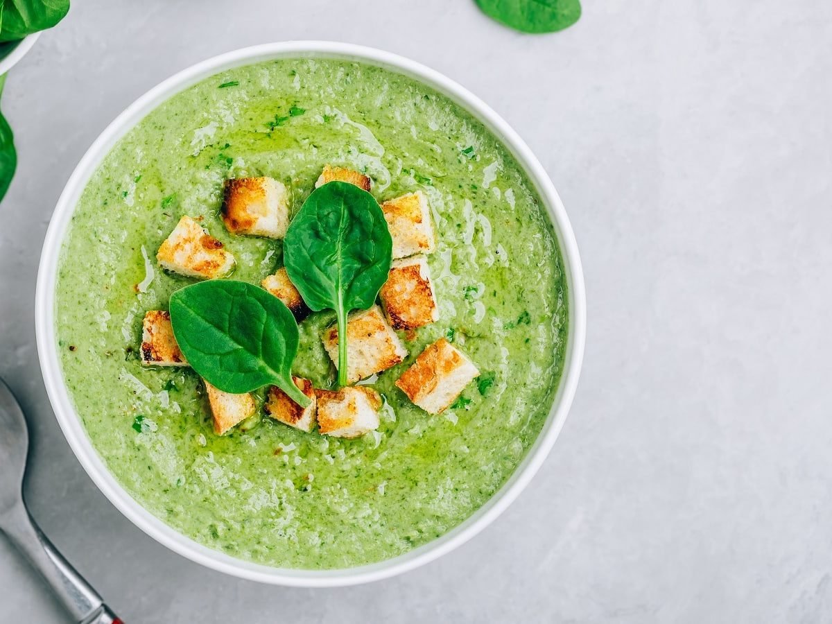 Eine weiße Suppenschüssel mit Spinatcremesuppe mit Gorgonzola.