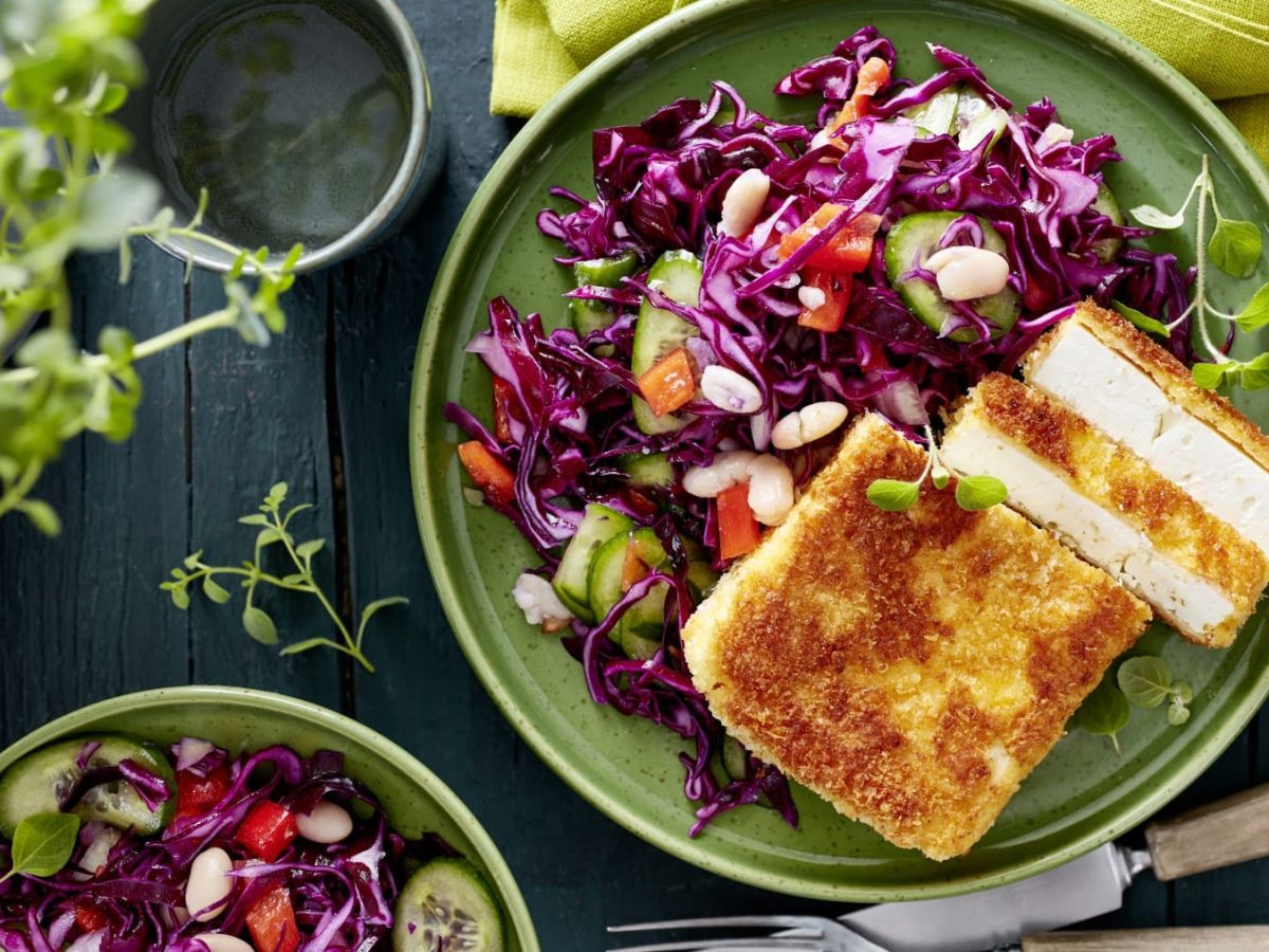 Feta-Schnitzel mit Wintersalat auf einem grünen Teller in der Draufsicht.