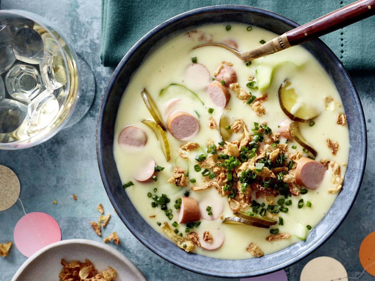 Eine Schüssel Hotdog-Suppe mit Röstzwiebeln und Schnittlauch in der Draufsicht.