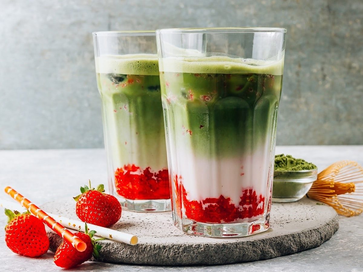 Zwei Gläser mit Matcha Strawberry Latte auf einem Teller.