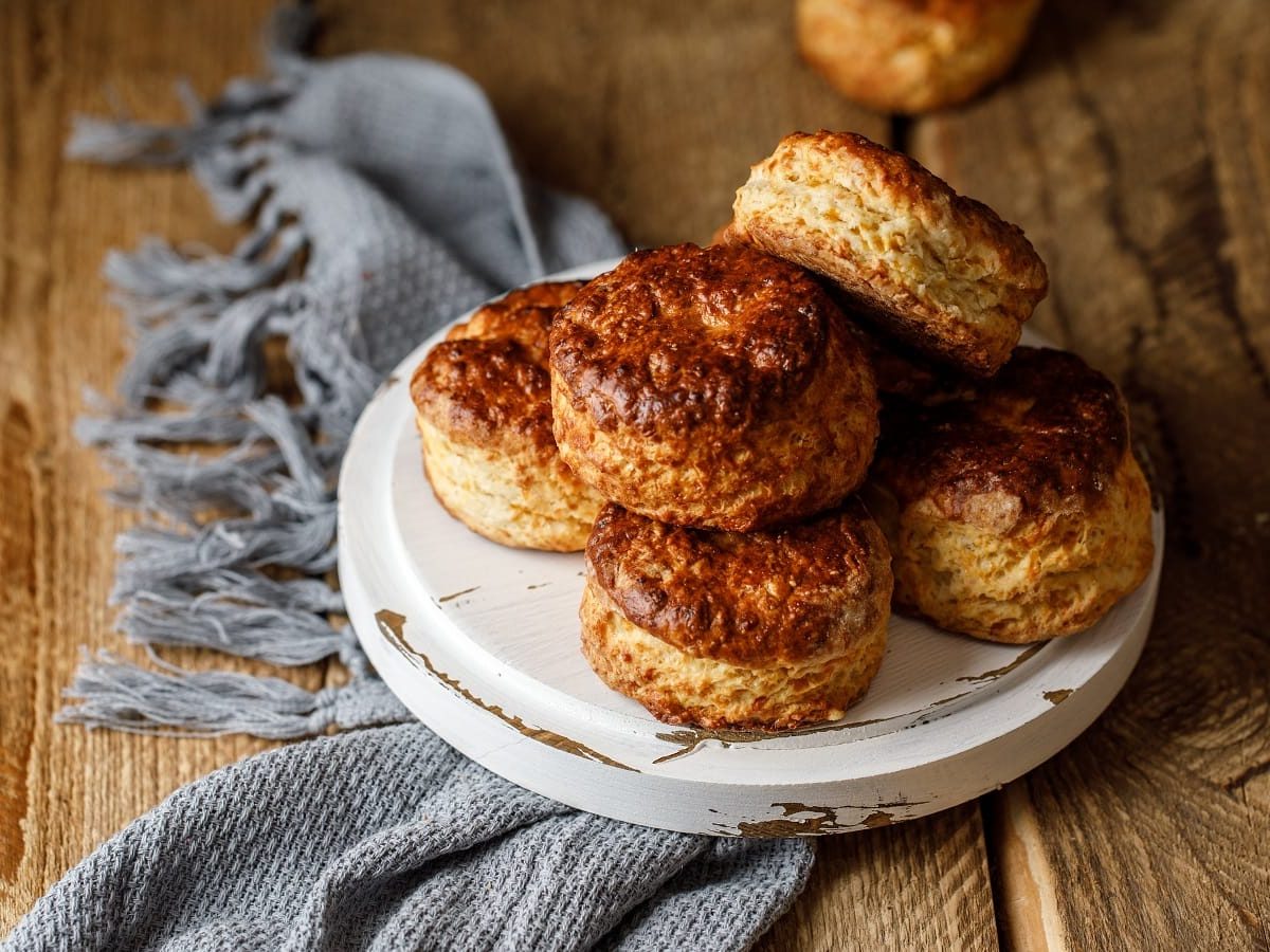 Ein Teller mit Cheddar Scones auf einem blauen Tuch.