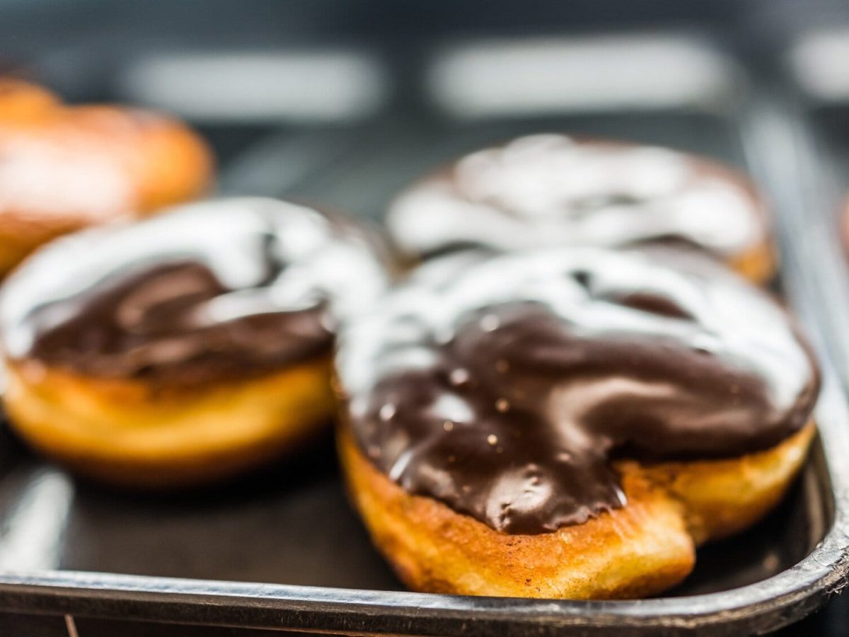 Vegane Boston Cream Donuts auf einem Tablett.