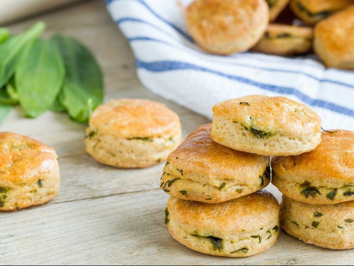 Ein Stapel Bärlauch-Scones, im Hintergrund unscharf weitere Scones und frischer Bärlauch.