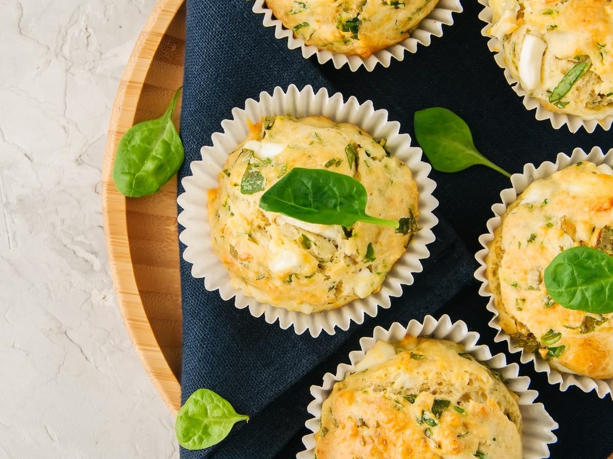 Ein rundes Holztablett mit Bärlauch-Muffins mit Feta.