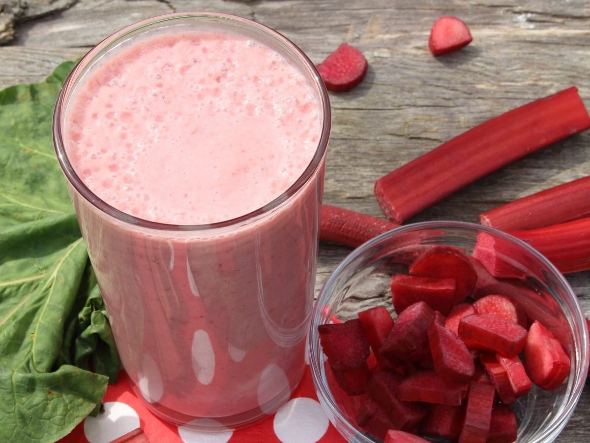 Ein Glas mit Rhabarber-Smoothie auf einem rot-weiß gepunkteten Tuch.