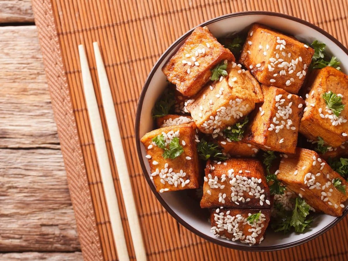 Eine runde Schüssel mit Miso-Tofu mit Chili auf einer Bambusmatte.