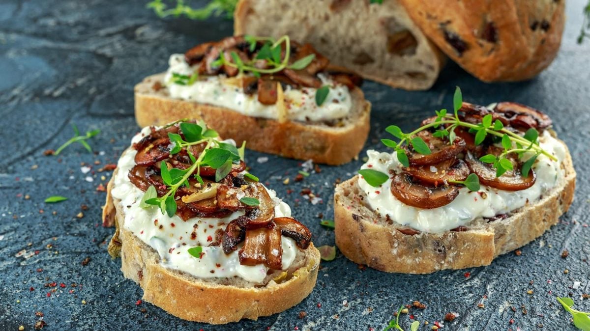 Drei Scheiben Pilz-Crostini mit Ricotta.