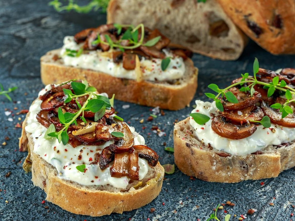 Drei Scheiben Pilz-Crostini mit Ricotta.