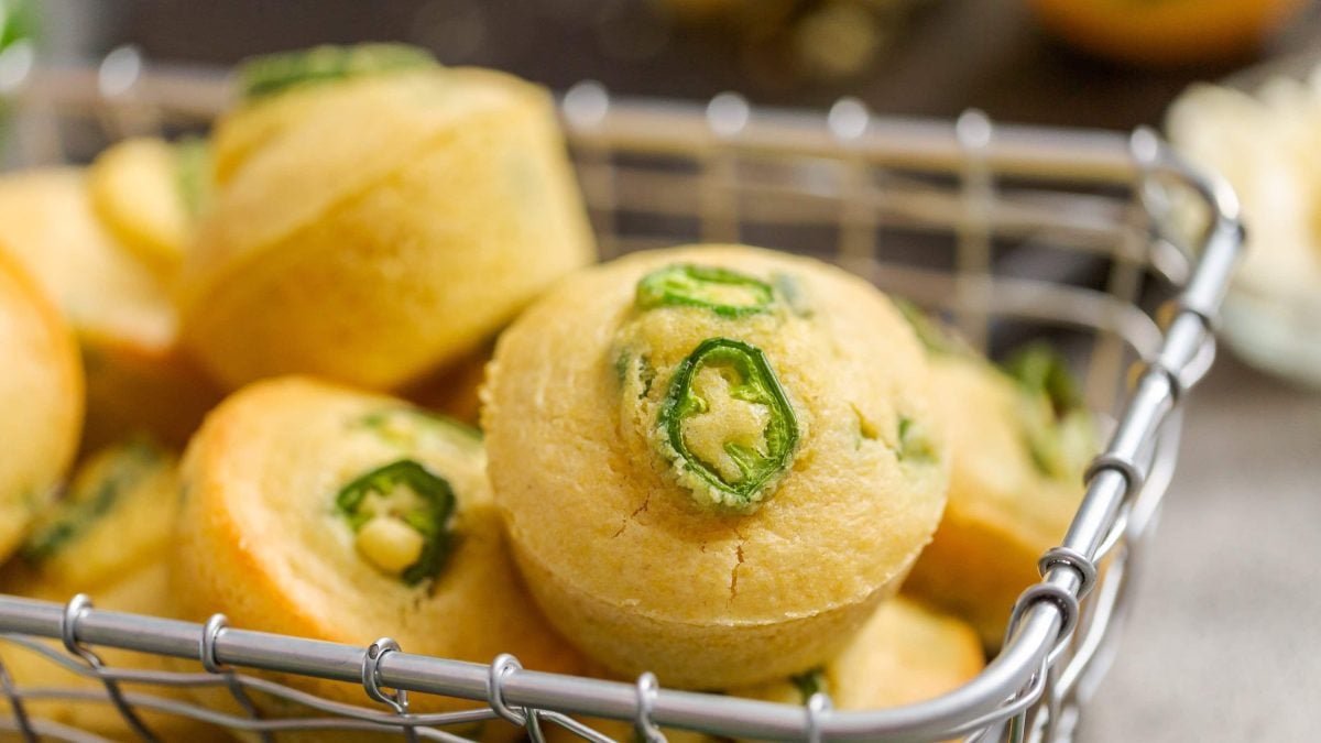 Ein Metallkorb mit den Chili-Cheese-Muffins auf einem hellen Tisch.