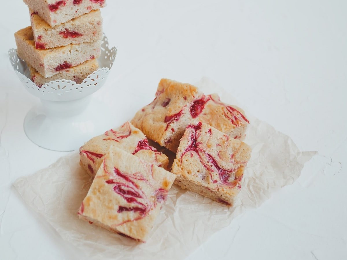 Ein paar Stücke Rhabarber Blondies auf weißem Hintergrund.