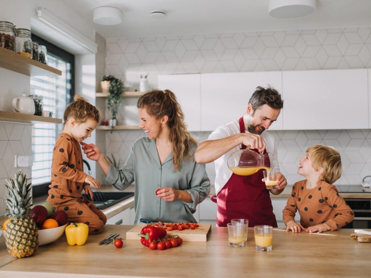 Eine Familie in der Küche beim Zubereiten von Familienrezepten. Frontalansicht.