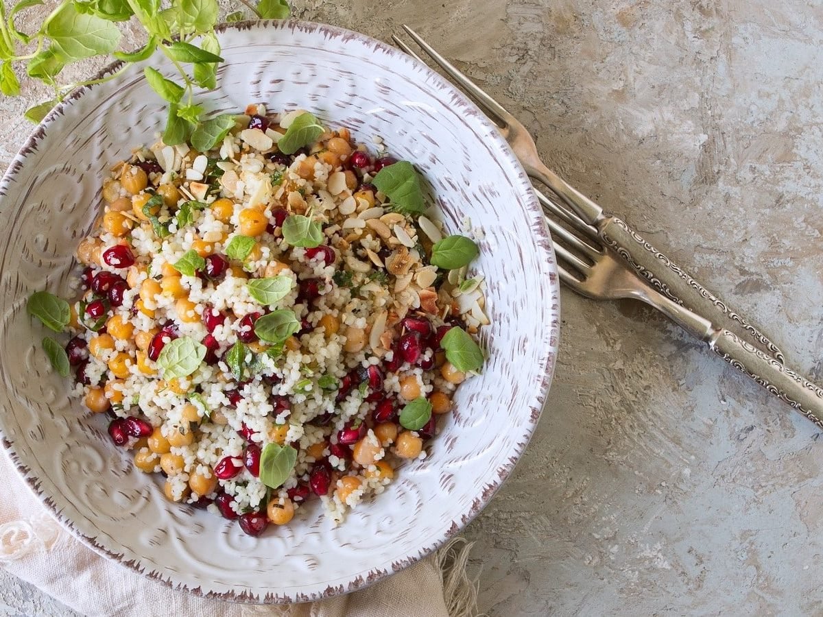 Ein Teller mit Granatapfel-Couscous mit Kichererbsen.