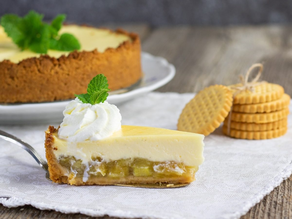 Ein Stück Rhabarber-Cheesecake auf einer Serviette mit Keksen.