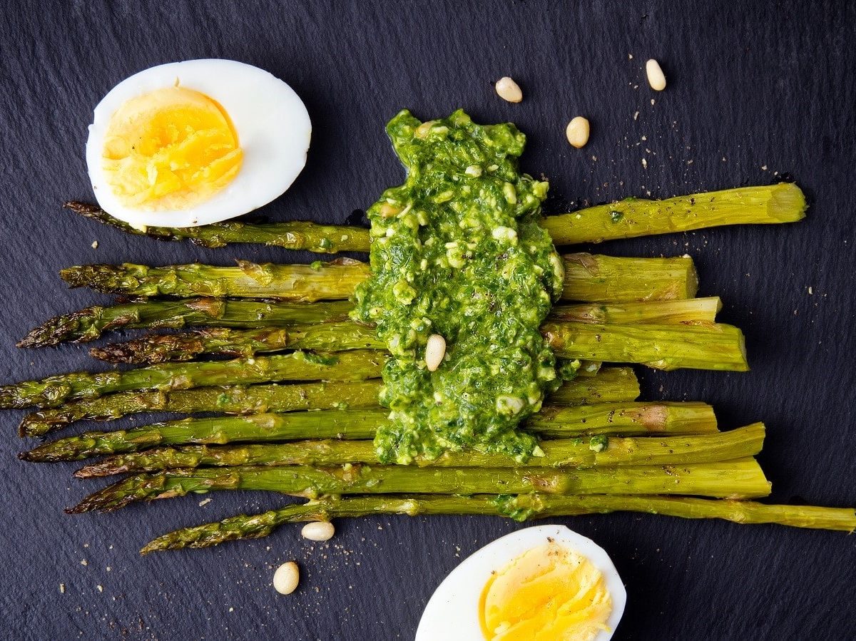 Gebackener Spargel mit Spargel-Pesto auf dunklem Hintergrund.