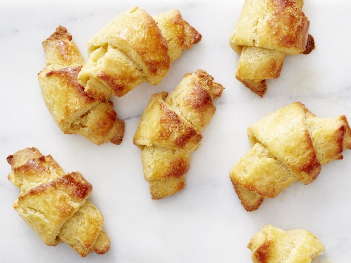 Sieben Keto-Knoblauchcroissants vor einem weißen Hintergrund.