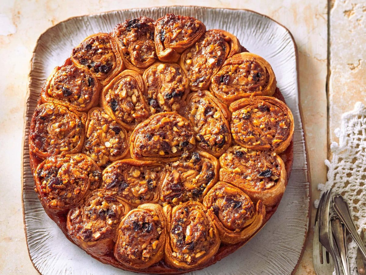 Ein weißer eckiger Teller mit dem Kuchen mit Nuss-Honig-Schnecken direkt von oben fotografiert.