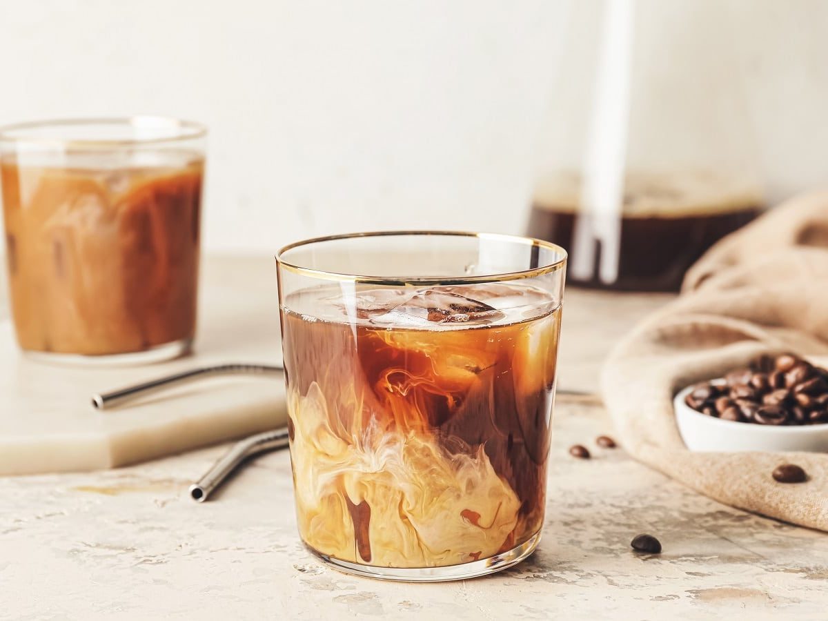 Ein Glas mit Vanilla Cold Brew Coffee auf einem hellen Tisch.