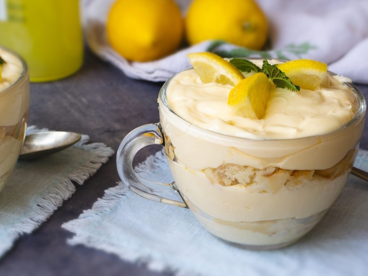 Zwei Gläser mit Limoncello-Tiramisu auf einem grauen Tisch.