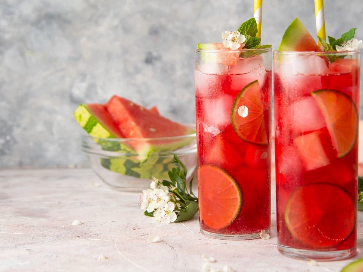 Zwei Gläser mit Wassermelonen-Limonade vor einem grauen Hintergrund.