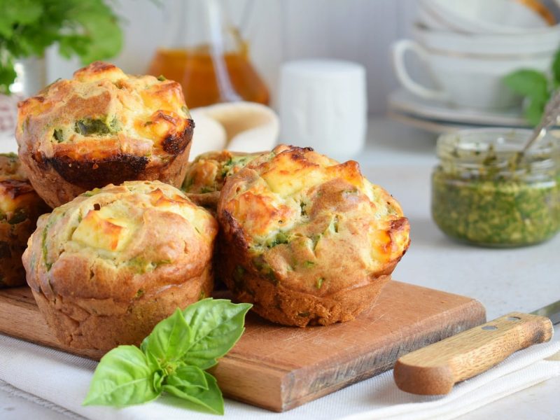 Ein paar Pesto-Muffins auf einem Holzbrett.