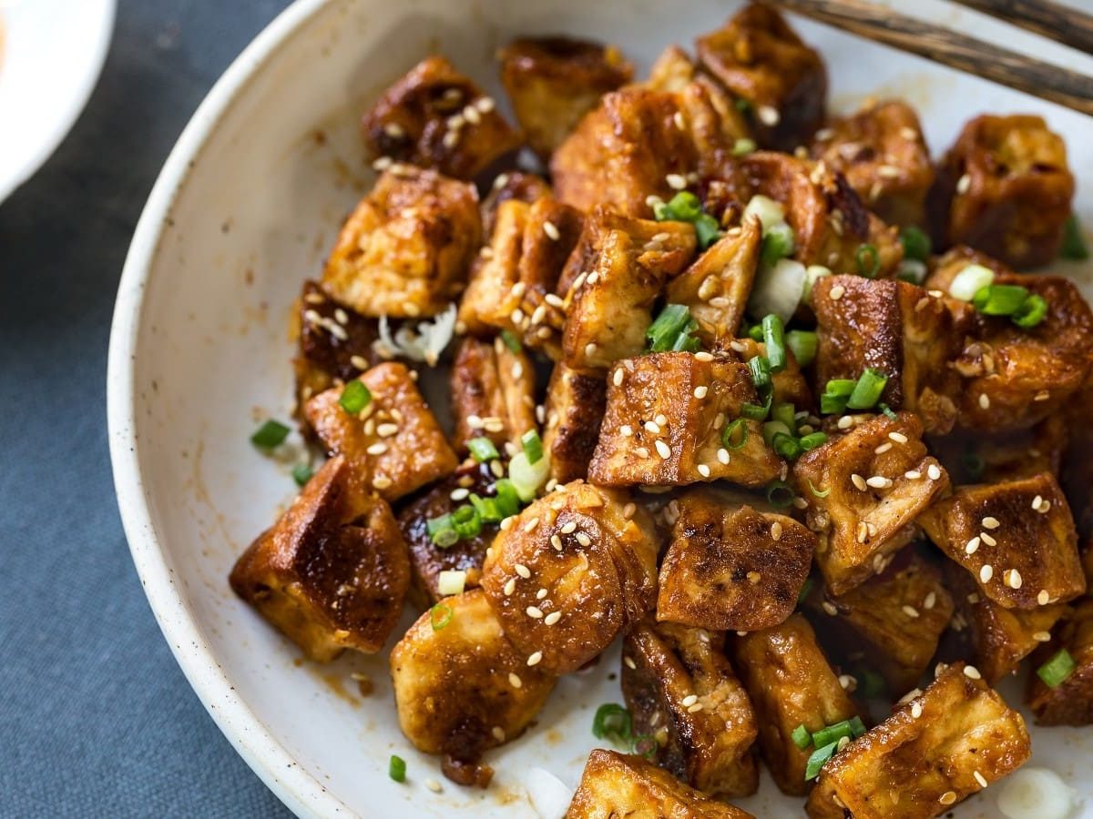 Ein Teller mit Popcorn Tofu auf einem grauen Untergrund.