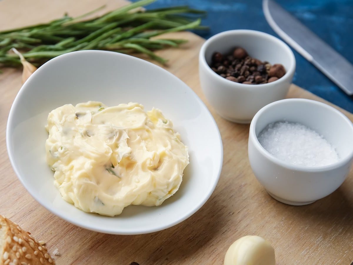 Eine Schüssel mit Sichuan-Pfeffer-Butter auf einem Holzbrett.