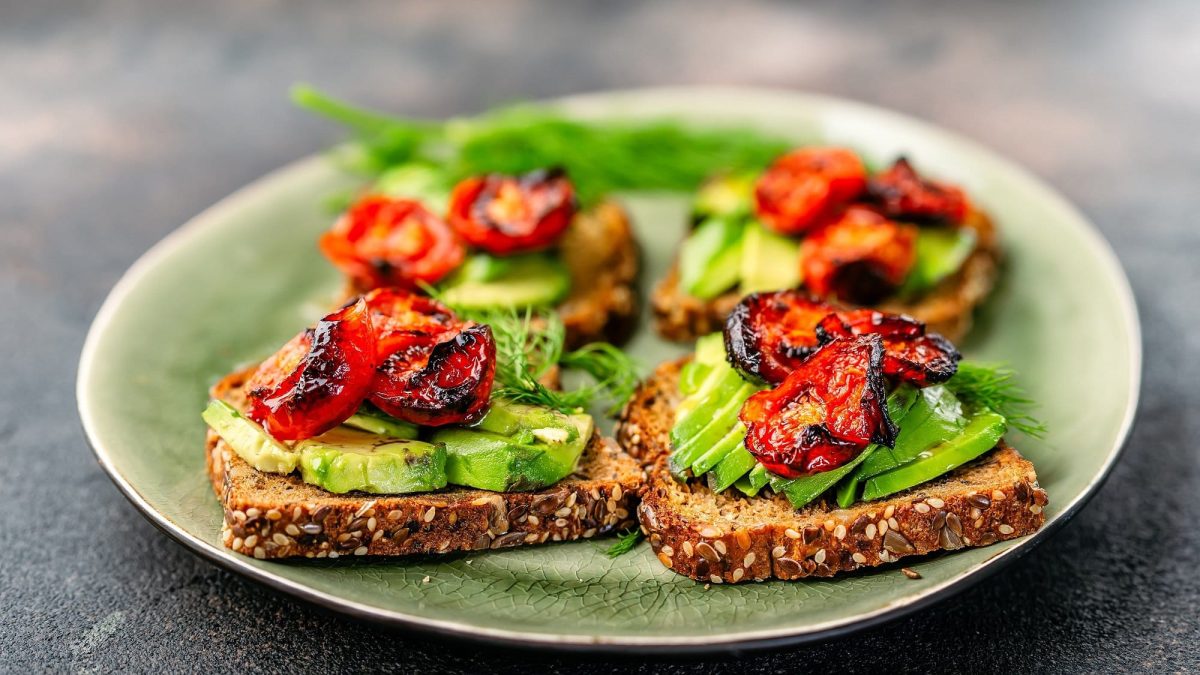 Ein Teller mit 4 Avocado-Stullen mit Rösttomaten