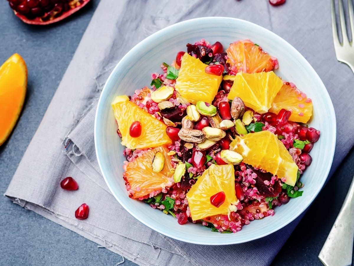 Eine Quinoa-Bowl mit Orangen und Rote Bete in einer hellblauen Schüssel.