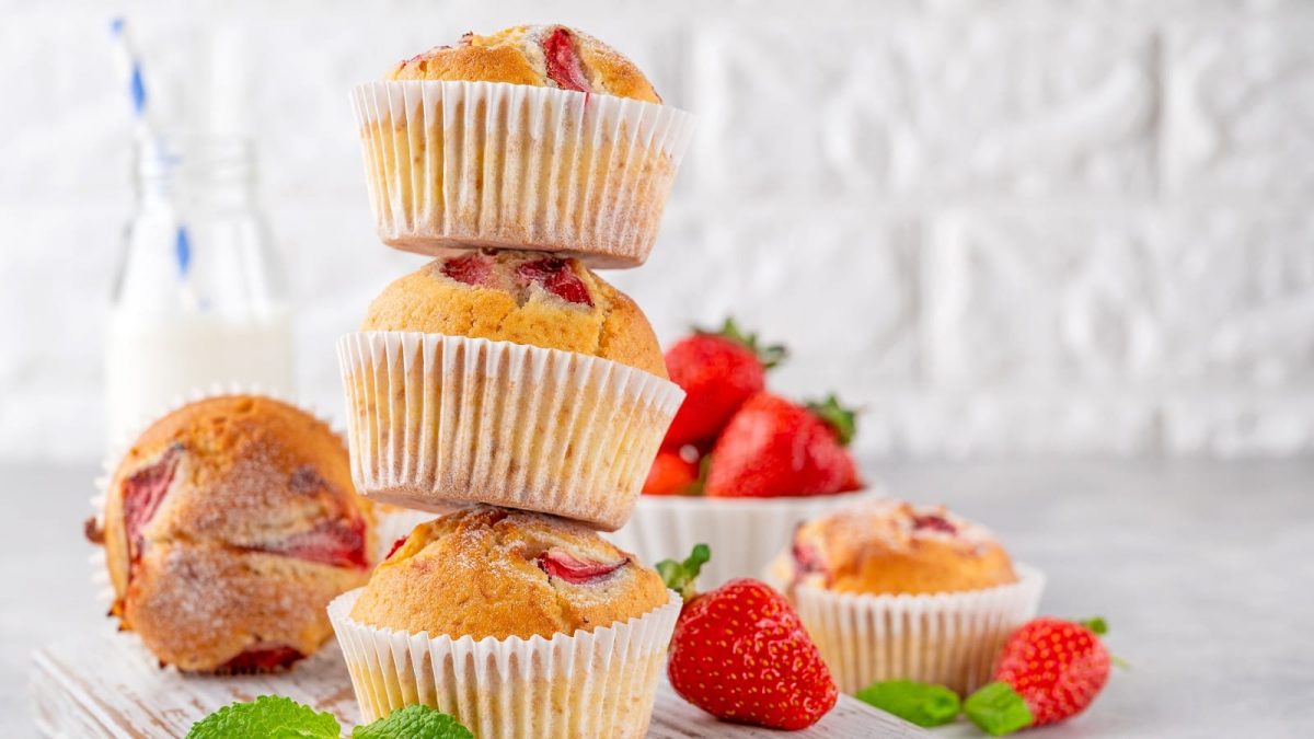 Ein Stapel mit Erdbeer-Ricotta-Muffins auf einem hellen Tisch,