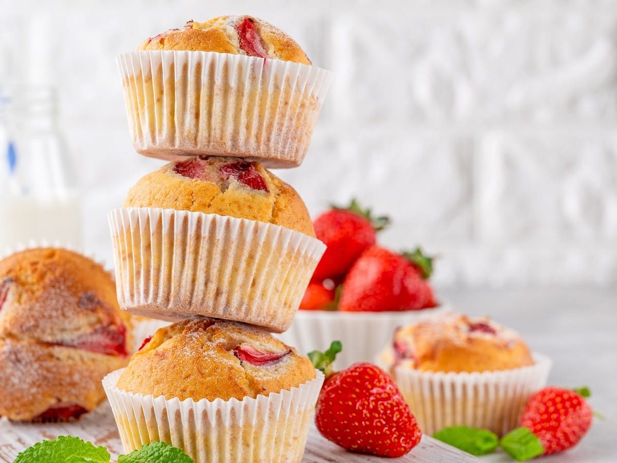 Ein Stapel mit Erdbeer-Ricotta-Muffins auf einem hellen Tisch,