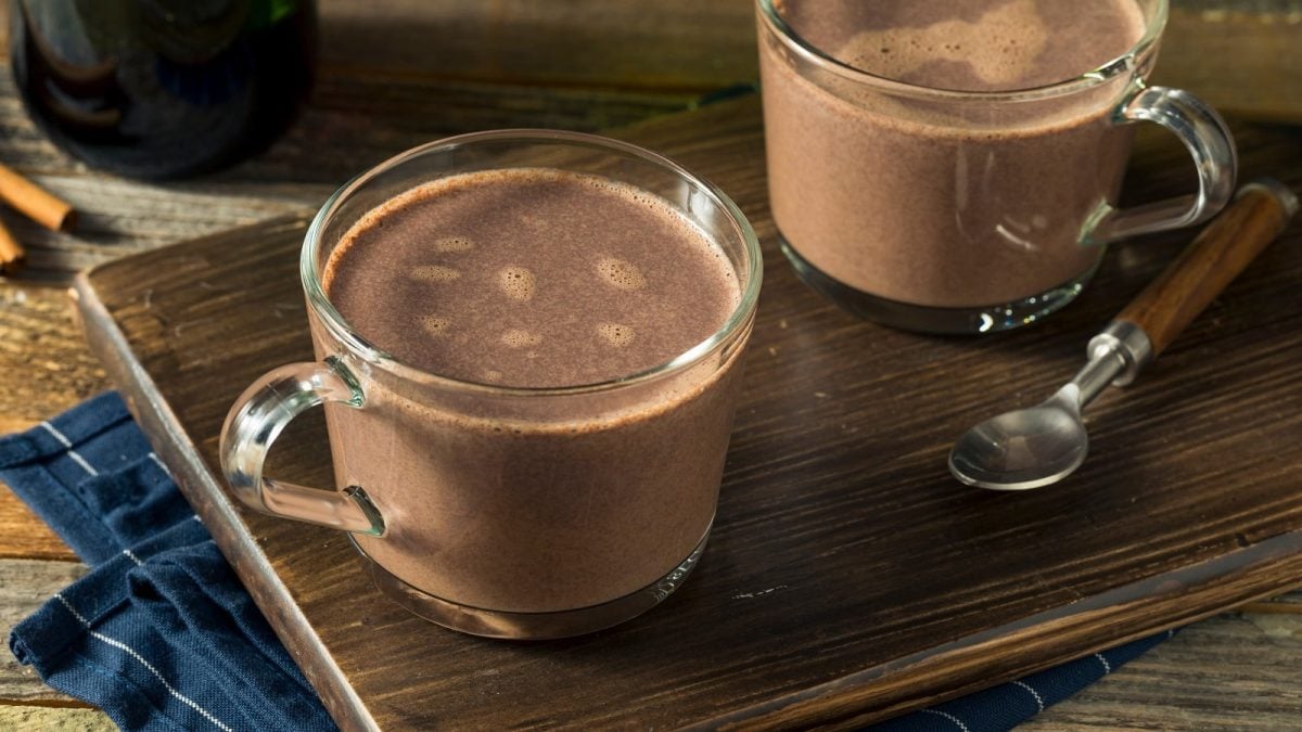 Zwei Glastassen mit Dark Mocha auf einem Holzbrett.