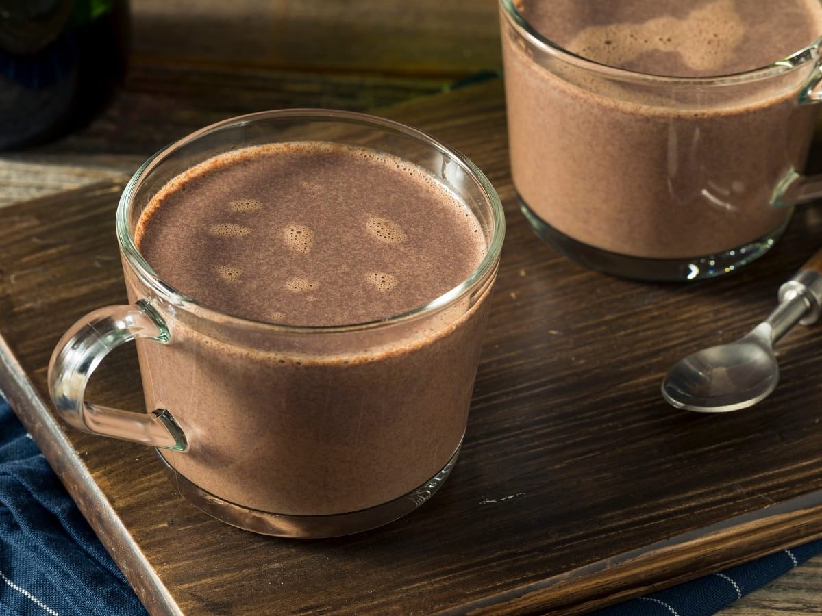 Zwei Glastassen mit Dark Mocha auf einem Holzbrett.