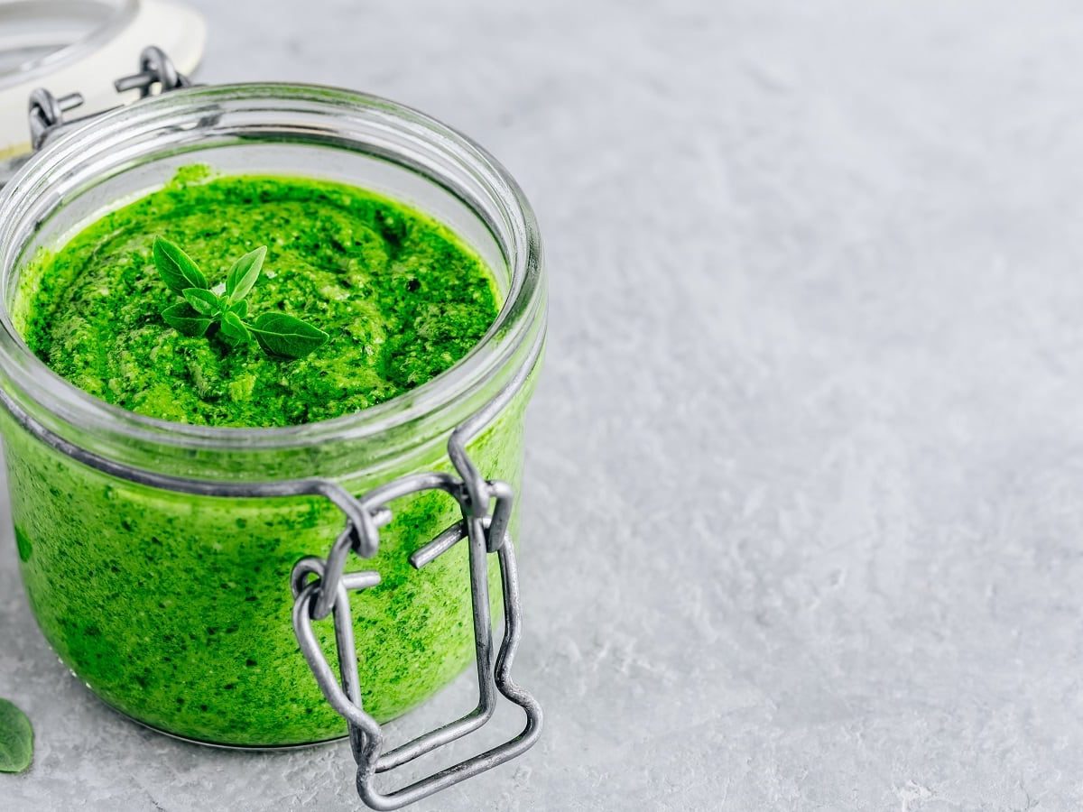 Ein Glas Salbei-Pesto auf einem grauen Untergrund.