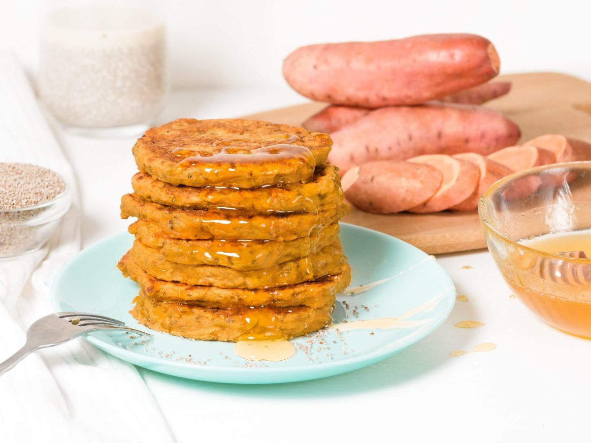 Ein Stapel Süßkartoffel-Pancakes auf einem blauen Teller.