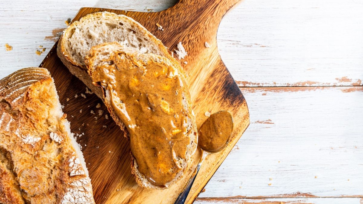 Ein Brot mit Spekulatius-Aufstrich auf einem Holzbrett.