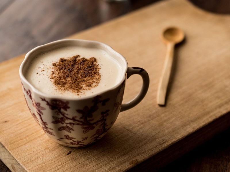 Eine Tasse Salep auf einem braunen Holztablett.