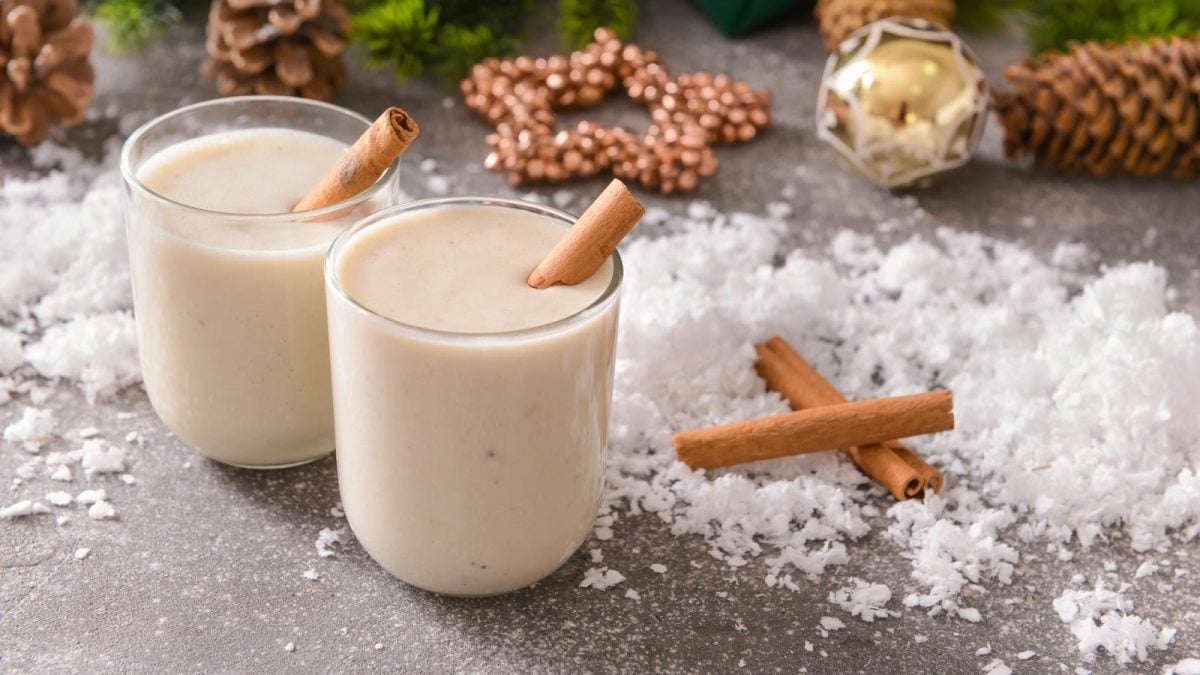 Zwei Gläser Spekulatius-Smoothie auf einem weihnachtlich gedeckten Tisch.