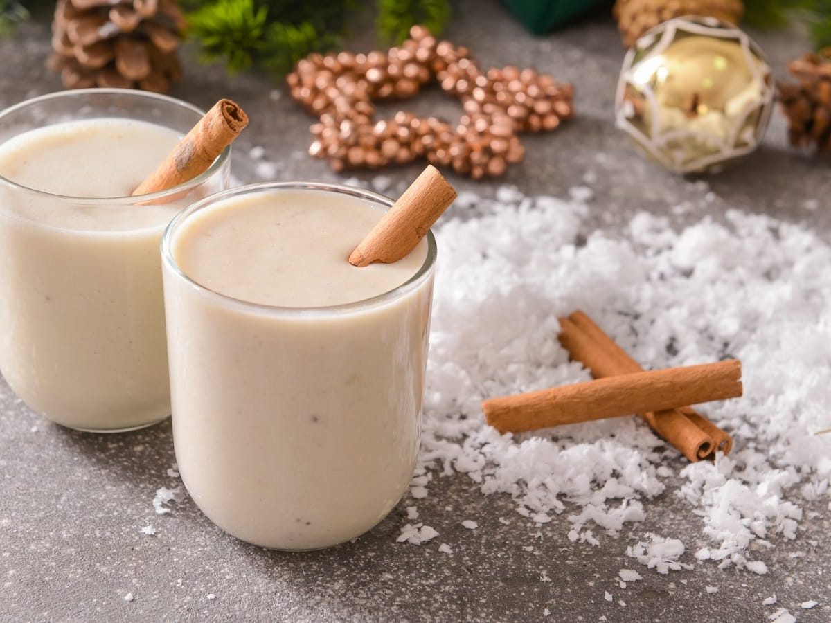 Zwei Gläser Spekulatius-Smoothie auf einem weihnachtlich gedeckten Tisch.