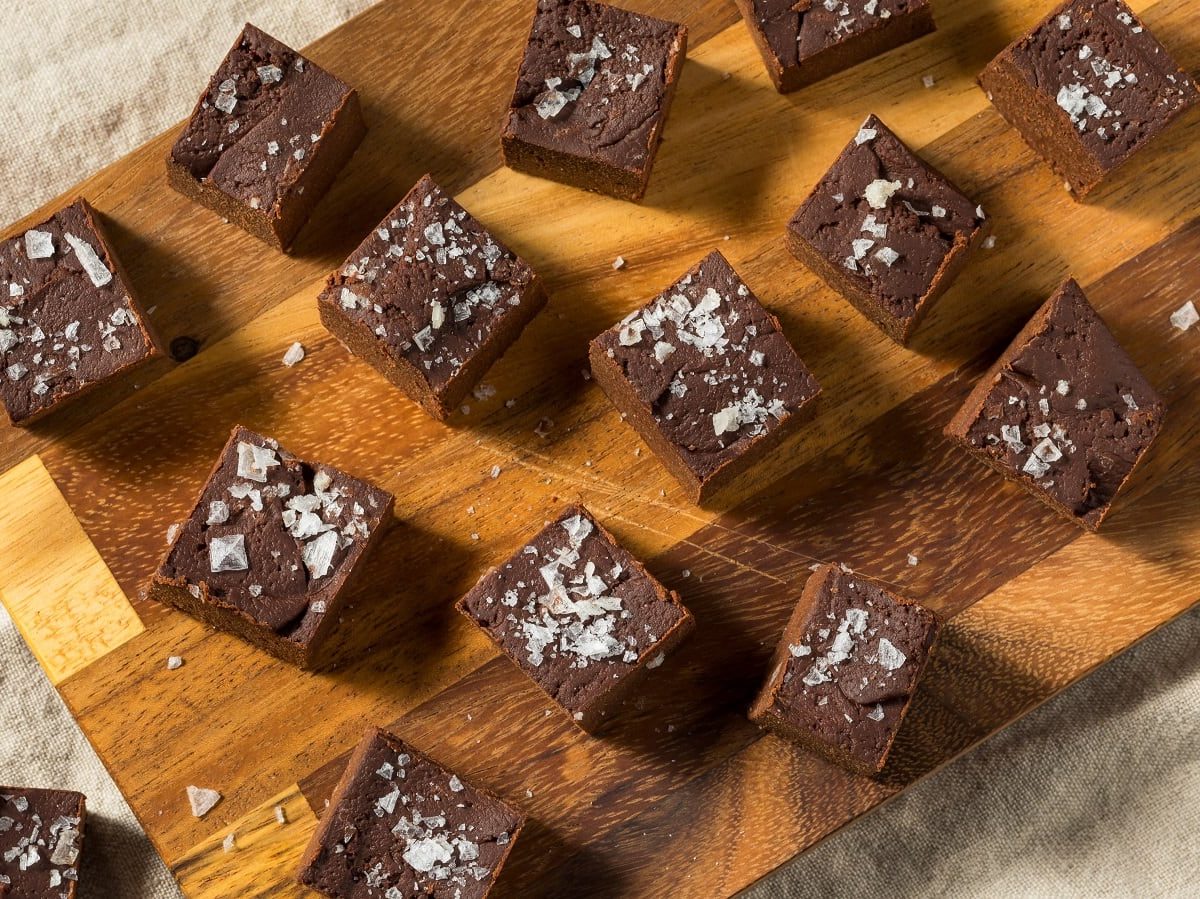 Ein Holzbrett mit Schoko-Süßkartoffel-Fudge auf einem beigen Tuch.