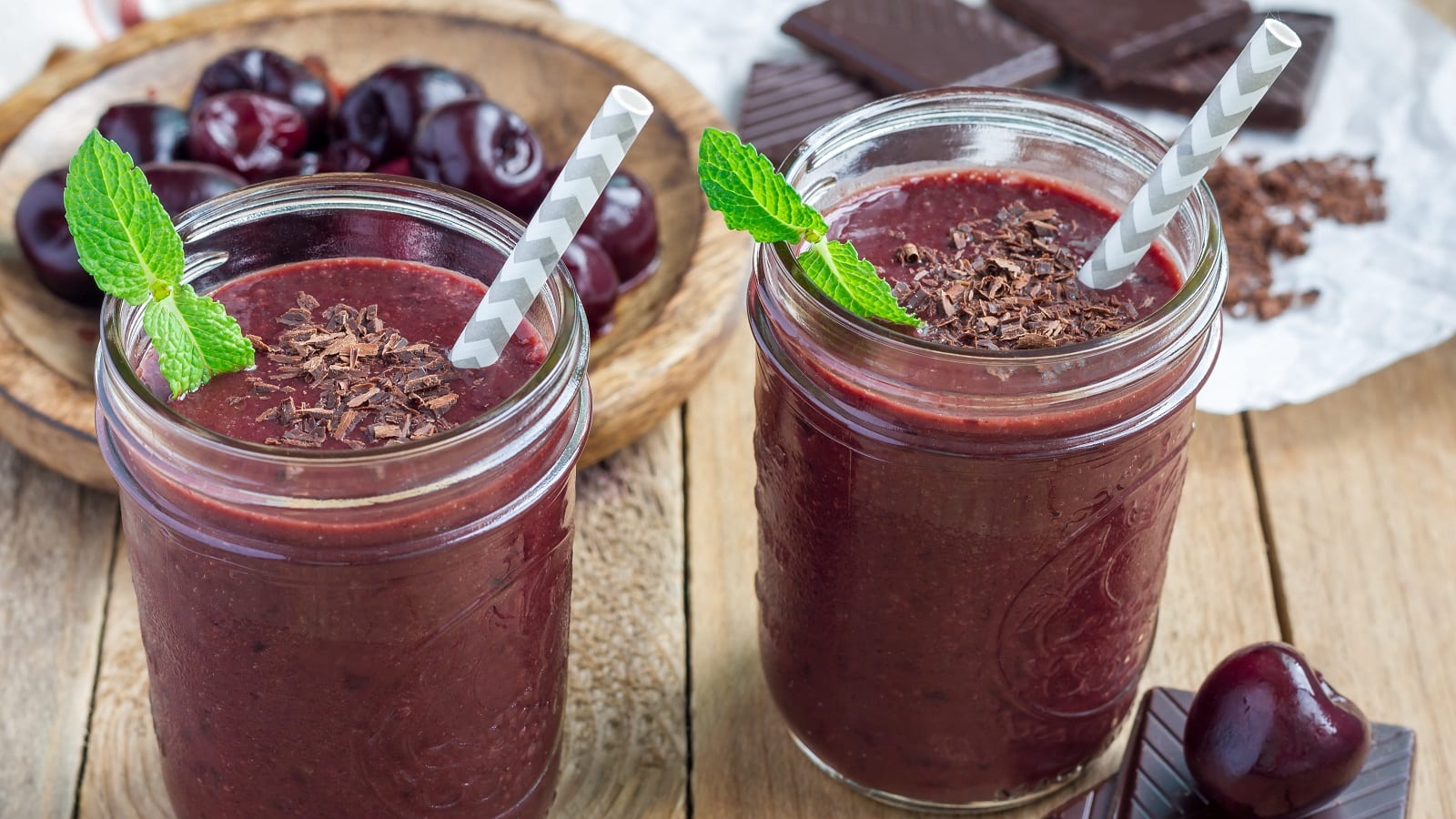 Zwei Gläser Schwarzwälder Kirsch-Smoothie auf einem Holztisch.