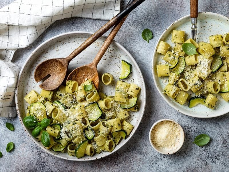 Zwei Teller mit Pasta e zucchine auf einem grauen Tisch