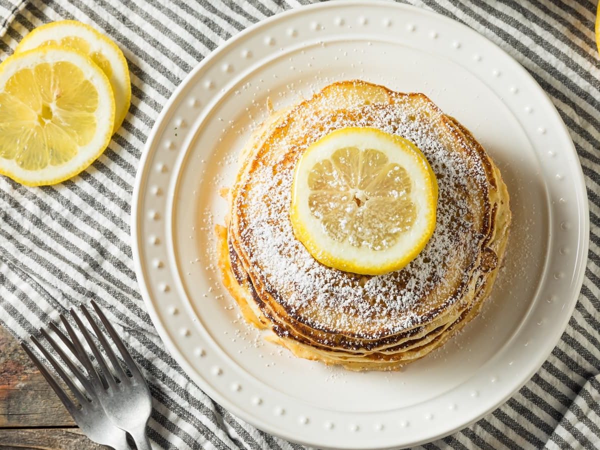 Ricotta-Zitronen-Pancakes auf einem gestreiften Tuch.