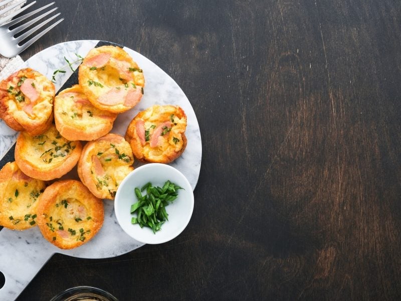 Ein weißer Teller mit einem Stapel Flammkuchen-Muffins.