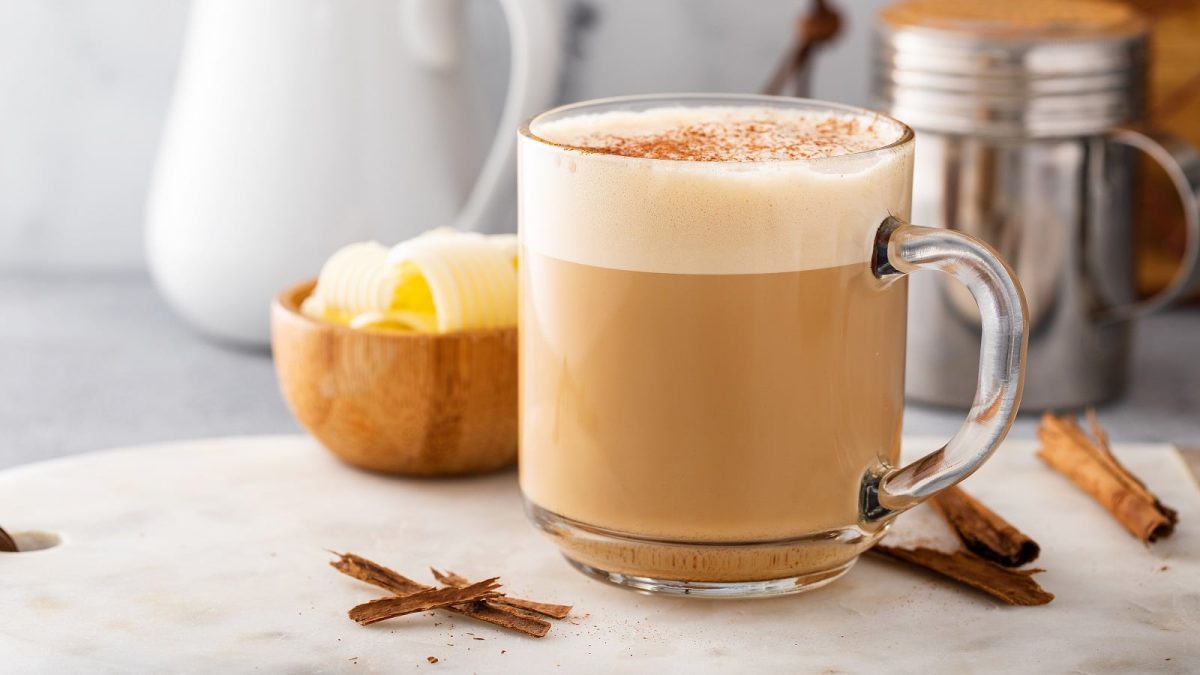 Eine Tasse Kokos-Zimt-Latte auf einem hellen Untergrund.