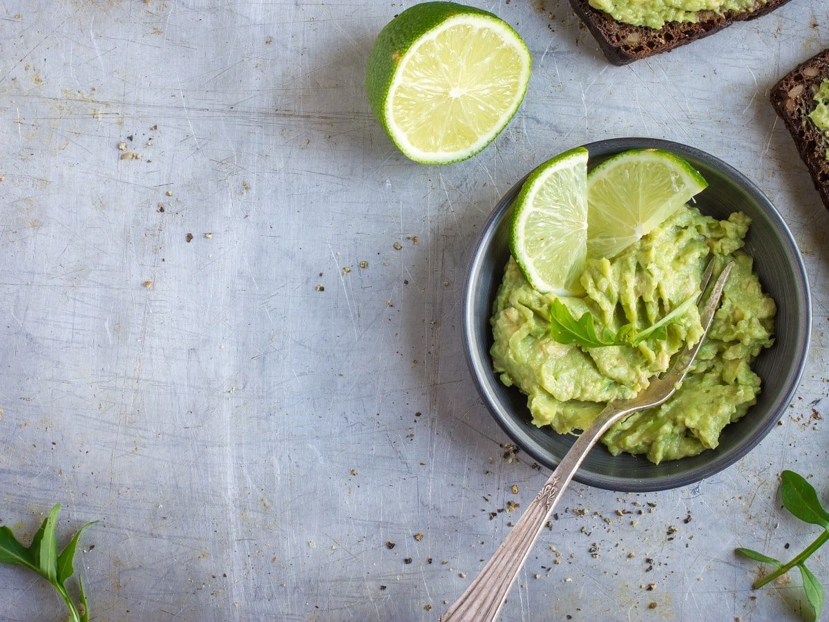 Eine Schüssel Rosenkohl-Guacamole auf einem grauen Untergrund.