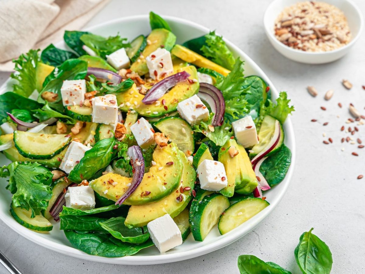 Ein weißer Teller mit dem Detox-Salat auf hellem Untergrund von schräg oben fotografiert.