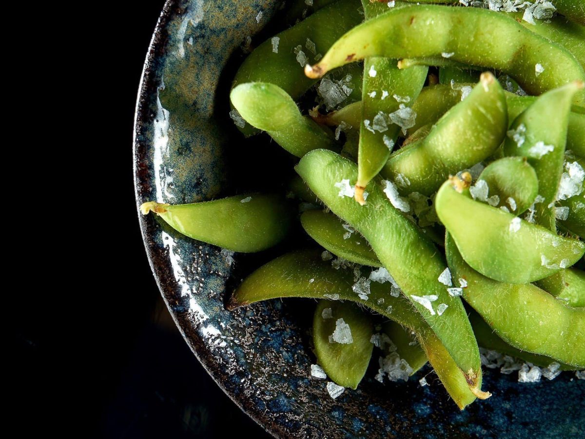 Draufsicht: eine Schale mit Edamame-Bohnen. / Wie isst man Edamame