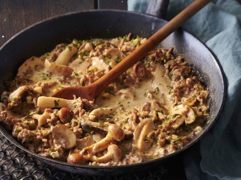 Pfanne mit gebratenem Hackfleisch und gemischten Pilzen in einer cremigen Sauce.